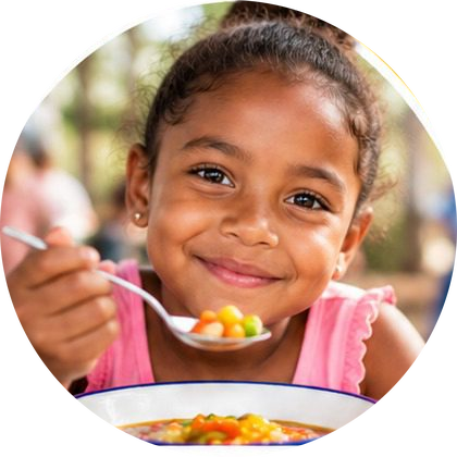 A girl eating a warm meal with a spoon